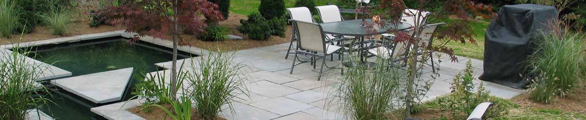 Modern square format stone patio with fish ponds